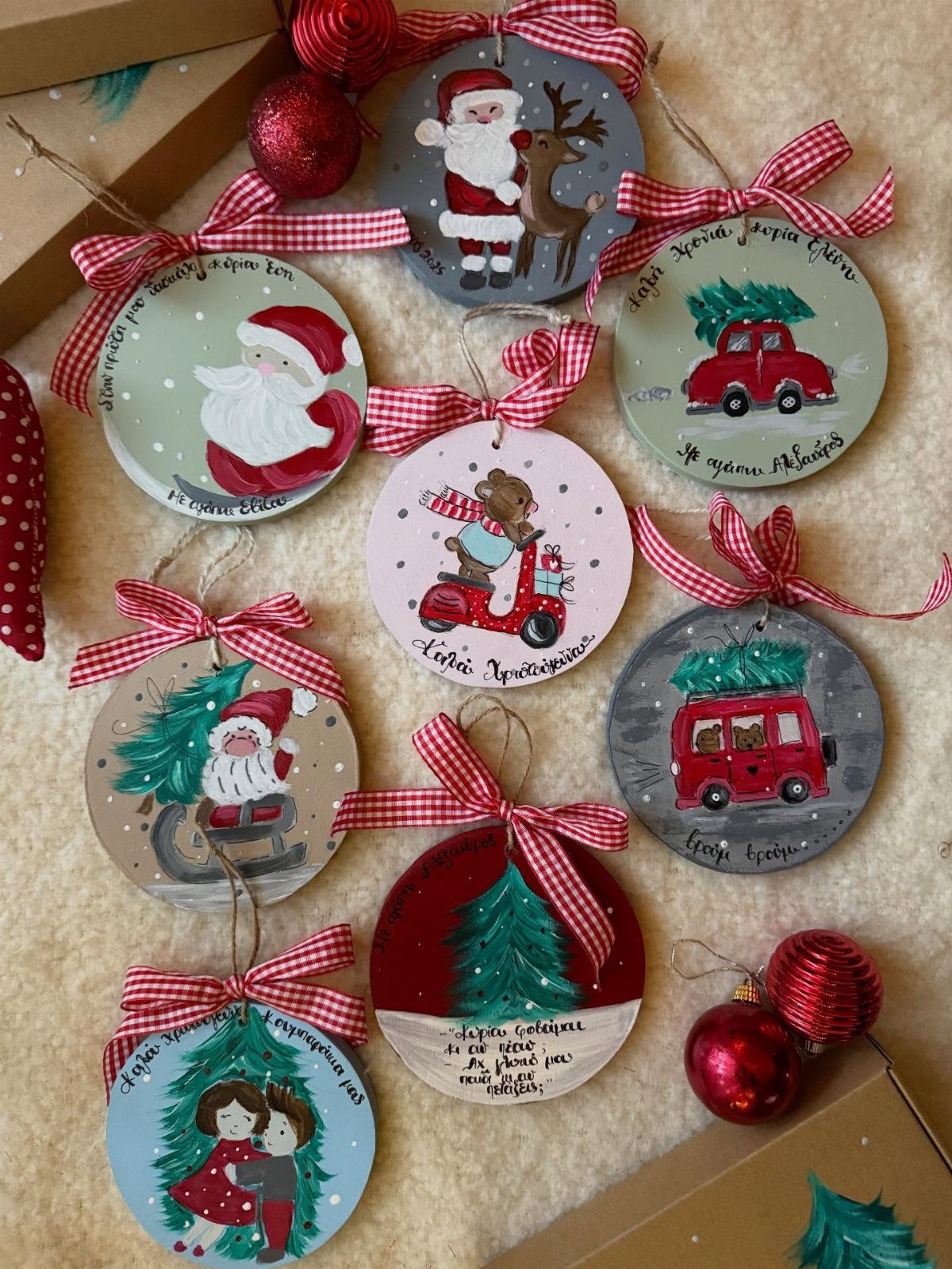 Circular wooden Christmas ornaments painted with festive scenes and tied with checkered ribbons.